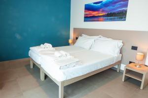 a bed with white sheets and towels on it at Corte Rocchetti Suite in Lazise +60 photos