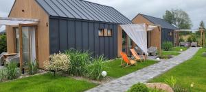 ein Haus mit schwarzem Dach und einem Hof in der Unterkunft Gemini MiniDomki in Ustka