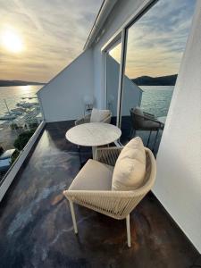 a balcony with chairs and tables on a yacht at Hotel BOUTIQUE in Tisno