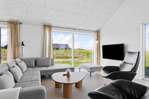 a living room with a couch and chairs and a tv at LN2067-Hjorring-Gabet-7 in Lønstrup