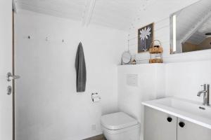 a white bathroom with a toilet and a sink at LN2067-Hjorring-Gabet-7 in Lønstrup +12 photos