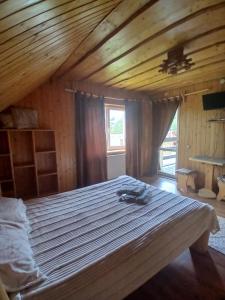 a large bed in a room with a wooden ceiling at Садиба Сонячний дім in Pilipets