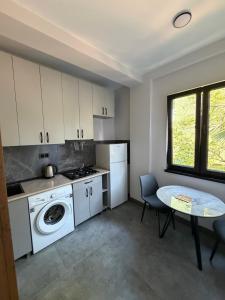 a kitchen with a table and a stove and a sink at Park Avenue Kobuleti in Kobuleti