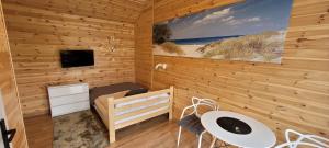ein Holzzimmer mit einem Bett und einem Fernseher in der Unterkunft Gemini MiniDomki in Ustka