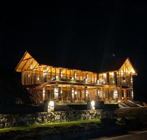 a large wooden building at night with lights at Woodland Resort in Naran