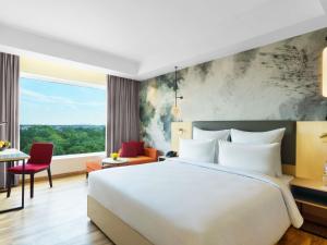 a hotel room with a bed and a large window at Novotel Jaipur Convention Centre in Jaipur