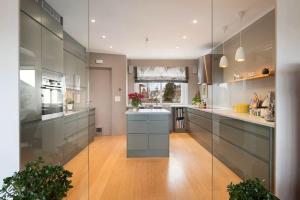 a large kitchen with gray cabinets and a wooden floor at Seaside House 5 BR in Garder