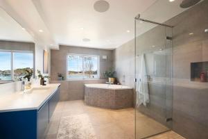 a bathroom with two sinks and a shower and a tub at Seaside House 5 BR in Garder +50 photos