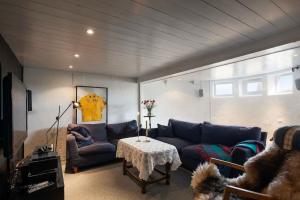 a living room with a blue couch and a table at Seaside House 5 BR in Garder