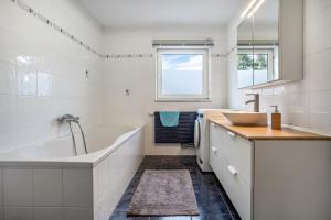 a white bathroom with a tub and a sink at Ferienwohnung 3 in Gribow