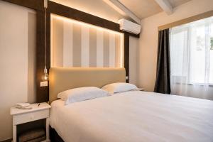 a bedroom with a large white bed and a window at Capo Vaticano Suites in Capo Vaticano +112 photos