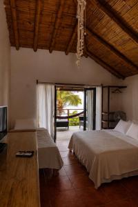 a bedroom with two beds and a large window at Los Cocos de Vichayito in Vichayito +67 photos