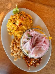 a plate of food with a bowl of rice and beans at Los Cocos de Vichayito in Vichayito