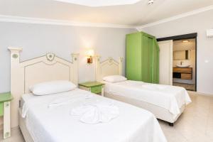a bedroom with two beds and a green cabinet at Villa Aysel Paradise in Dalyan +54 photos