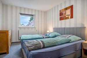 a bedroom with a bed with blue sheets and a window at Ferienwohnung 3 in Gribow