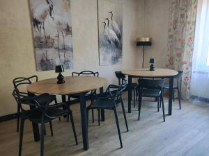 two tables and chairs in a room with paintings at Weekendowo Miejsce i Czas Agroturystyka in Wyszogród