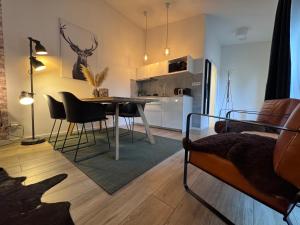 a living room with a table and chairs and a kitchen at Apartmány Benešov in Benešov nad Ploučnicí