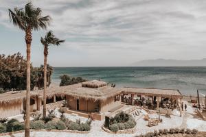a view of a house with palm trees and the ocean at Sagredo Beachfront Retreat & Spa by E-GEO in Ágios Fokás