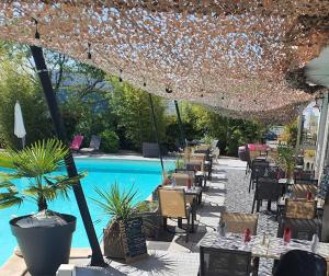 a patio with tables and chairs and a pool at Le Clos de Sangonis in Saint-André-de-Sangonis +5 photos