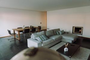 a living room with a couch and a table at Casa da Barca Pool & Golf by TonsdeVerde in Esposende