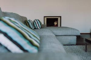 a living room with a couch and a man in a mirror at Casa da Barca Pool & Golf by TonsdeVerde in Esposende