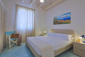 a bedroom with a bed and a chair and a window at Passione Mare in Porto Palo +114 photos