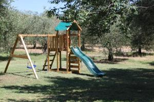 a wooden playground with a slide and a swing at Il Girasole Terzuolo in Manciano