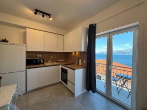 a kitchen with a view of the ocean at Apartman Bugenvila Postira Brač in Postira