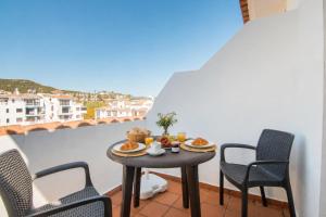 a table with food on a balcony with chairs at 2233-Lovely 2 bedrooms on the beach, pool and port in Manilva