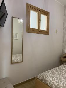 a bedroom with a mirror and a bed at Etna Guest House in Belpasso