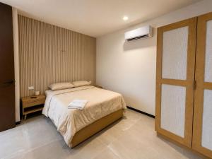 a small bedroom with a bed and a window at Private villa among palms in Telchac in Telchac Puerto