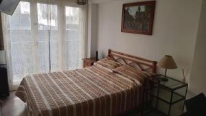 a bedroom with a bed and a window at Depto Brown in Mar del Plata