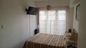 a bedroom with a bed and a window at Depto Brown in Mar del Plata