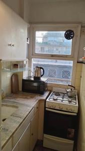 a small kitchen with a stove and a window at Depto Brown in Mar del Plata