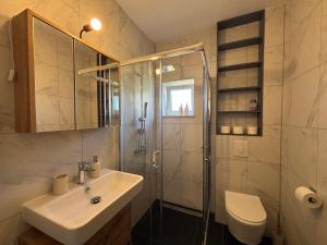 a bathroom with a sink and a shower and a toilet at Apartman Bugenvila Postira Brač in Postira +16 photos