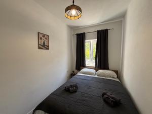 a bedroom with a bed and a window at Apartman Bugenvila Postira Brač in Postira