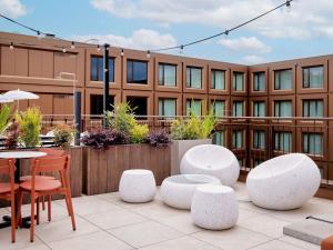 a patio with chairs and tables and a building at TRIBE Milano Malpensa in Vizzola Ticino