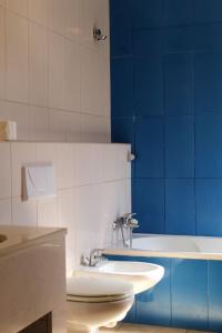 a bathroom with two sinks and a blue wall at Baia da Barca in Madalena +63 photos