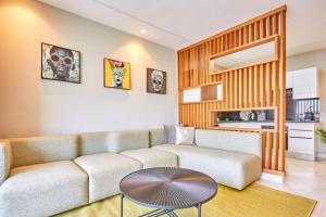 a living room with a couch and a table at Stunning Studio Pool View CFC Casablanca in Casablanca