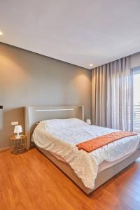 a bedroom with a large bed in front of a window at Stunning Studio Pool View CFC Casablanca in Casablanca +38 photos