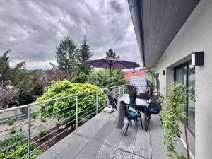 a balcony with a table and an umbrella at Apartmány Benešov in Benešov nad Ploučnicí