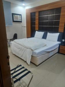 a bedroom with a large bed and a chair at مؤسسة علي عايض سداح الدوسري للمقاولات in Abu Arish