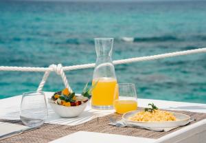 a table with a plate of food and a bottle of orange juice at Capo Vaticano Suites in Capo Vaticano