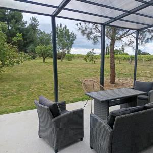 a patio with a table and chairs and a field at Appartement Marilou in Pompiey