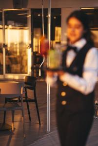 a woman standing in front of a table and chairs at Capo Vaticano Suites in Capo Vaticano