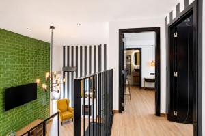 a living room with a green brick wall at Palheiro 81 Ocean View in Costa Nova