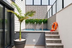 a house with a swimming pool and a palm tree at Palheiro 81 Ocean View in Costa Nova