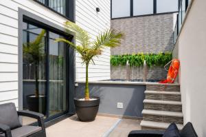a patio with two palm trees and a staircase at Palheiro 81 Ocean View in Costa Nova