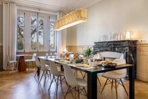 a dining room with a black table and white chairs at L'Autre Rives in Albi