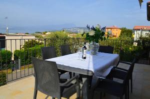 a table with chairs and a vase of flowers on a balcony at La casa di Viola in Bardolino